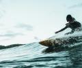 A surfer carves a turn on a wave.