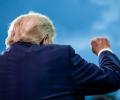 Viewed from behind, Trump raises a fist.