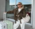 Influencer Molly_Mae poses beside her luggage.