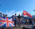 A Union Jack is draped over a railing, next to a red flag saying Jesus.