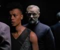 A woman confronts a man whose clone stands behind her.