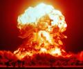 A nuclear explosion glows red and orange against the night sky.