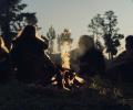 A re-enactment of an ancient 'caveman' family sitting around a camp fire.