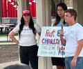 Mourning students at a vigil hold a sign about Charlie Kirk.