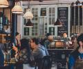 People sit in a busy cafe.