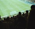 A view from a football stand over heads to the pitch.