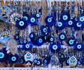 Blue evil eye charms hang among a jewellery display