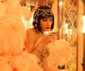 Taylor Swift, dressed as a showgirl, sips from a glass.
