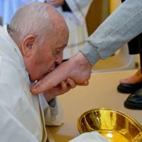 The Pope kisses a foot he has just washed.