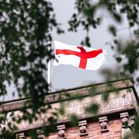A St George's Cross flag flutters on a tower.