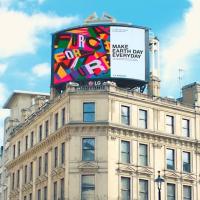 A digital billboard on top of a London building reads: Make Earth Day Everyday.