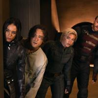 Four characters from a film loop warily to the side.