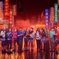 Contestants in Race Across the world stand in front of neon-lit Chinese street scene