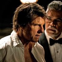 Tom Cruise playing Ethan Hunt in an open necked shirt looks perplexed.