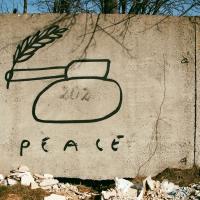 Graffiti of a tank with a peace laurel coming out of its barrel.