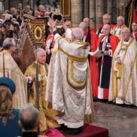 An archbishop crowns the king. 