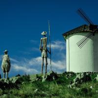 Statues of Don Quixote and Sancho Panza point toward a windmill