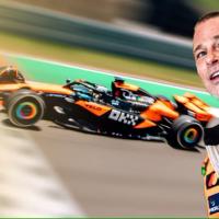 Brad Pitt dressed as a racing driver stands with a car in the background