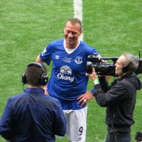 A footballer is interviewed on the side line.