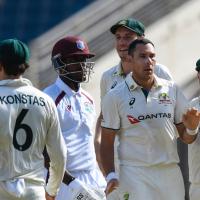 A cricket batsman surrounded by opposition players leaves the crease.