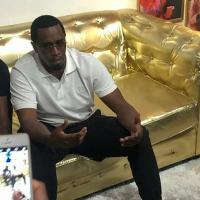 Sean Combs sits on a golden couch.