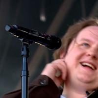 A singer leans back from the mic smiling