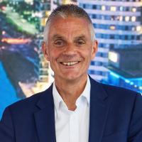 Tim Davie in a blue suite smiles