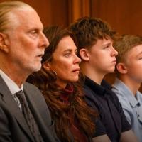 A family sit together watching a trial in a court.