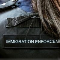 A Border Force officer wears body armour with Immigration Enforcement written on the back