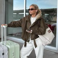 Influencer Molly_Mae poses beside her luggage.