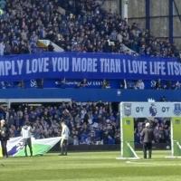A football stand displays a long banner with text on it.