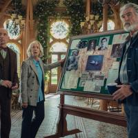 Elderly amateur sleuth stand by their pinboard.