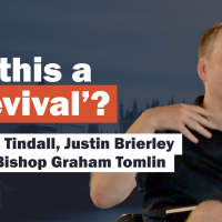 A video caption card show a speaker holding a mike and the text 'Is this a revival?'