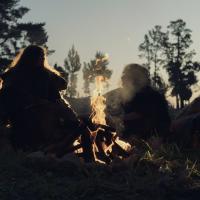 A re-enactment of an ancient 'caveman' family sitting around a camp fire.