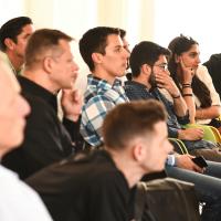 young people listen, and ponder, to a speaker off screen.