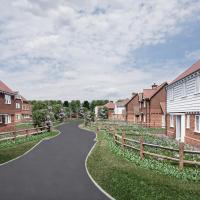 A render of a new housing estate showing a road, wooden fences and clapperboard hosues.
