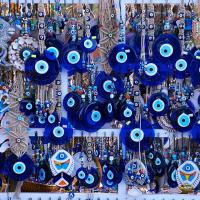 Blue evil eye charms hang among a jewellery display