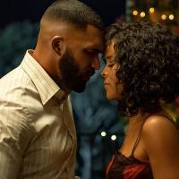 A couple hold each others hands as they face each other.