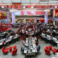 A wide angle view of the BBC newsrooms show a starm layout of desks