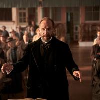 An Edwardian choirmaster conducts.